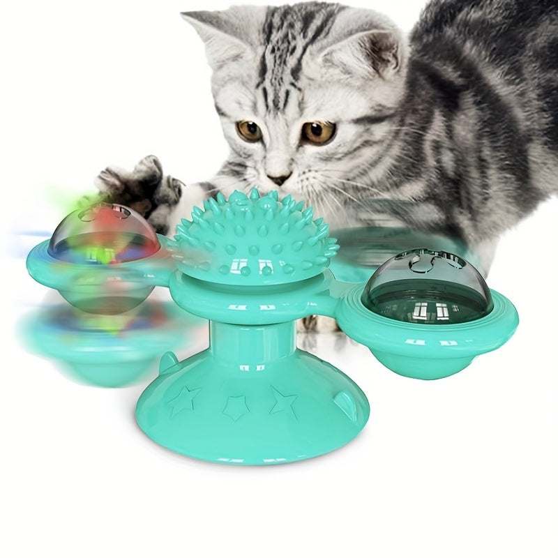 Gray tabby kitten playing with turquoise windmill cat toy with spinning ball and textured middle ball
