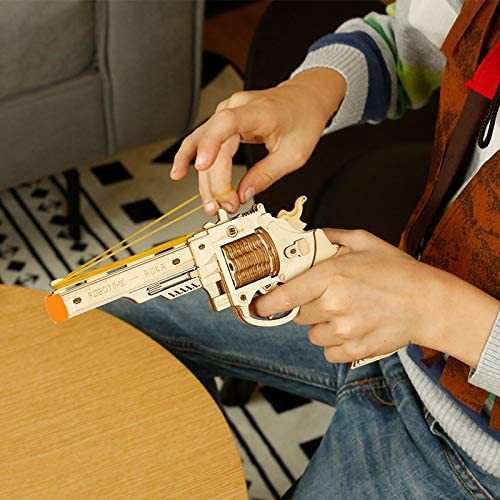 Child assembling and playing with Robotime Gun Blocks wooden model kit toy