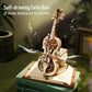 Robotime ROKR Magic Cello 3D wooden puzzle music box with self-playing bow and intricate gear design on vintage book base