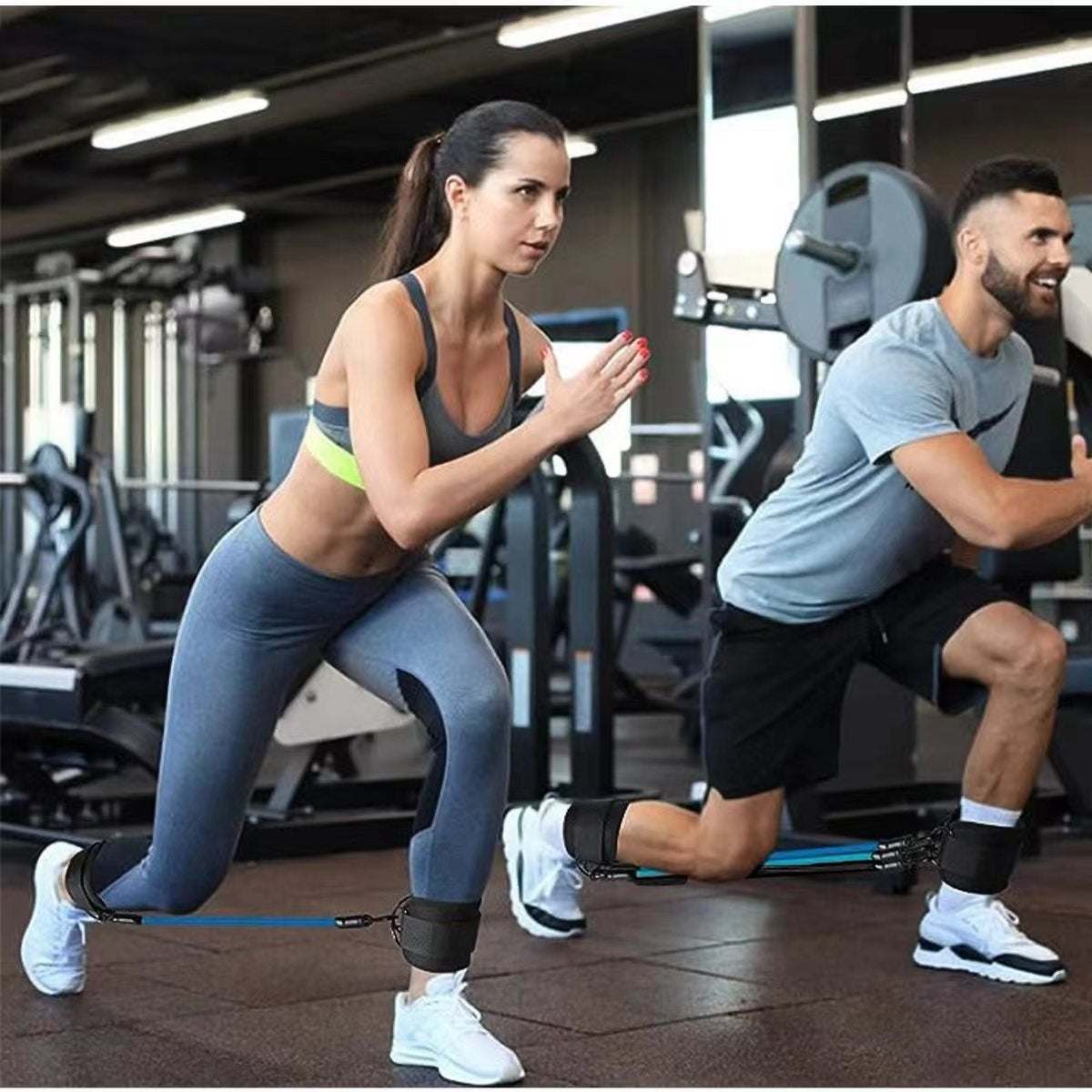 Two people exercising in gym using ankle strap resistance bands for leg and hip strength training