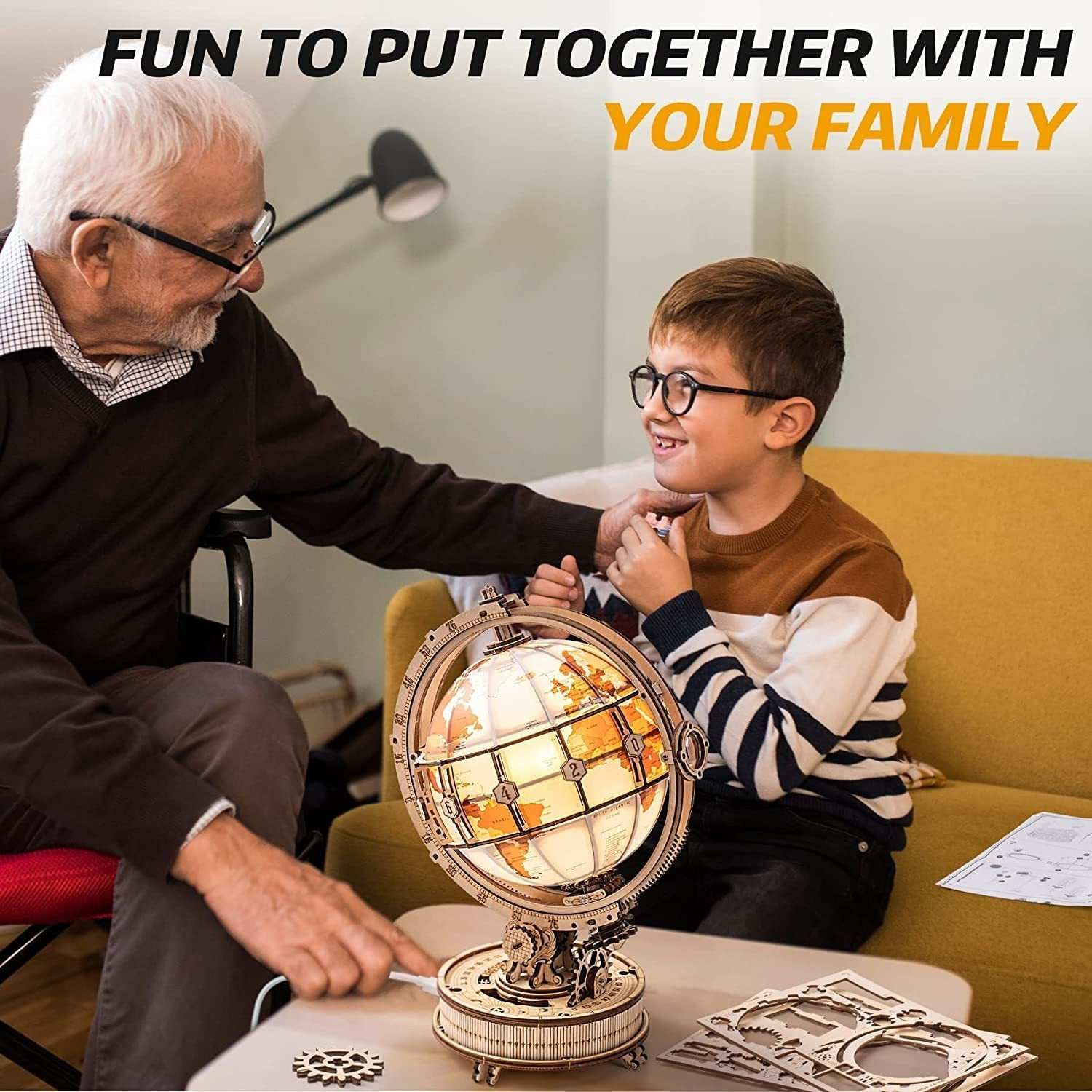 Grandfather and grandson assembling Rokr Luminous Globe 3D wooden model kit at home