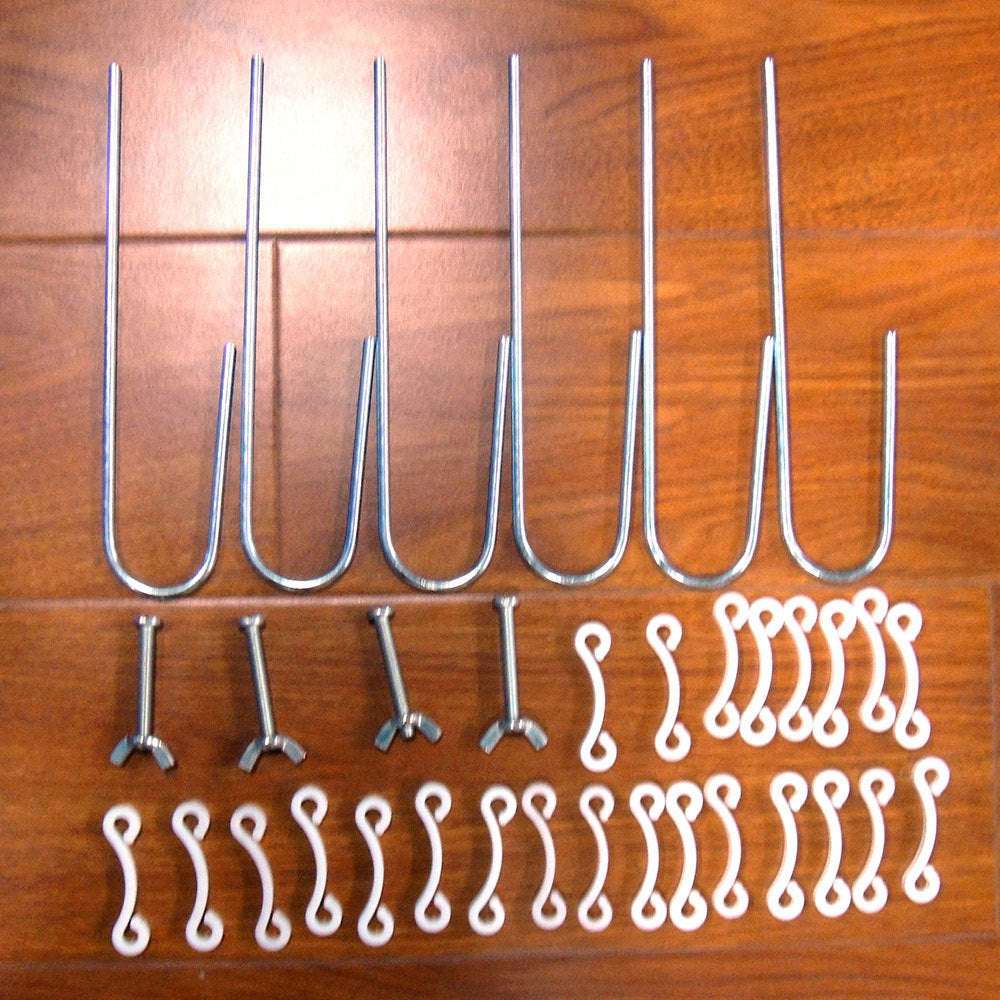 Metal ground nails and white net buckles for 8' x 5' soccer goal assembly set on wooden surface